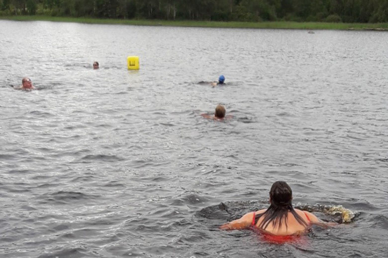 Personer simmar i Vesljungasjön och kontrollerar sin simkunnighet.