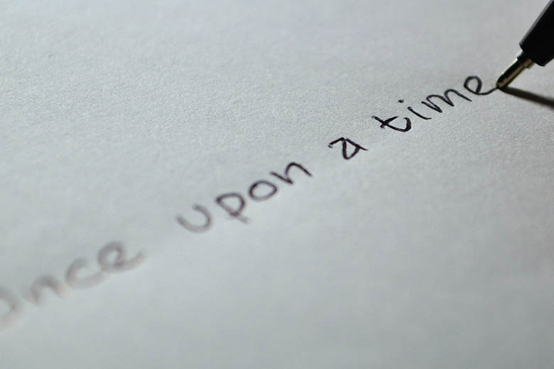 Bild på penna som skriver Once upon a time på vitt papper