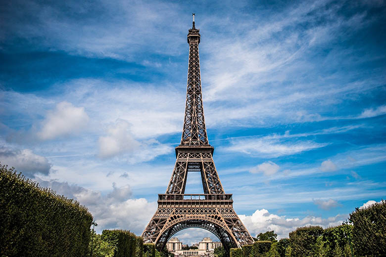 Bild på Eiffeltornet i Paris mot en blå himmel.