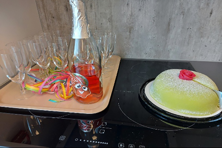 Princesstårta och bubbel ligger på en bricka. Bredvid brickan finns flera champangeglas. 