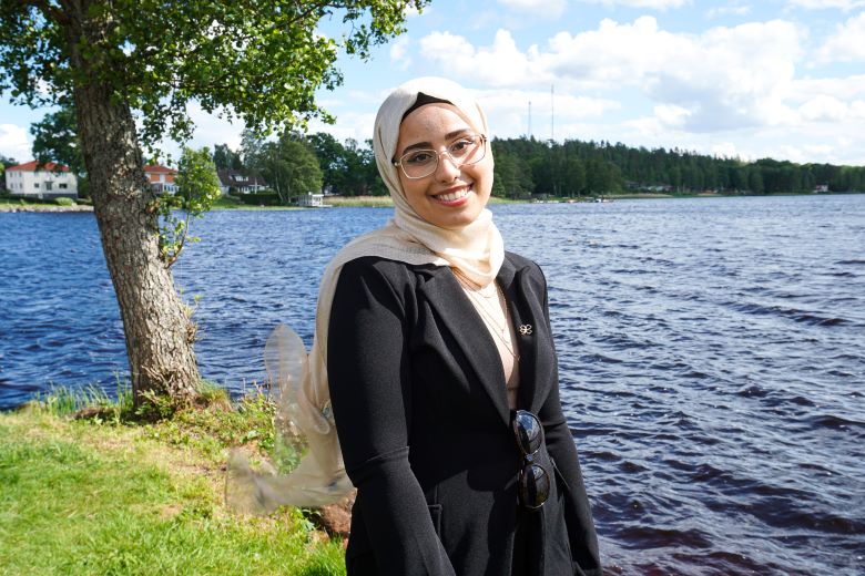 Amina står nere på prästängen med sjön i bakgrunden