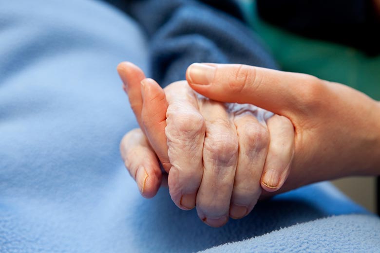 En hand som håller i en seniors hand