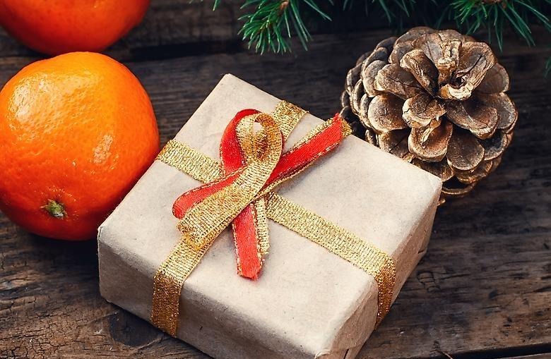 Julklapp, apelsin och kotte under en julgran